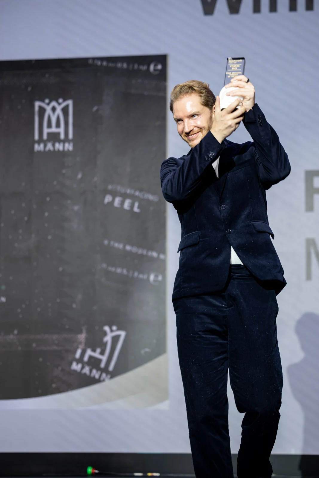 Kenneth Hoellmann raising the MÄNN Skincare award on stage at Beautyworld Middle East 2025