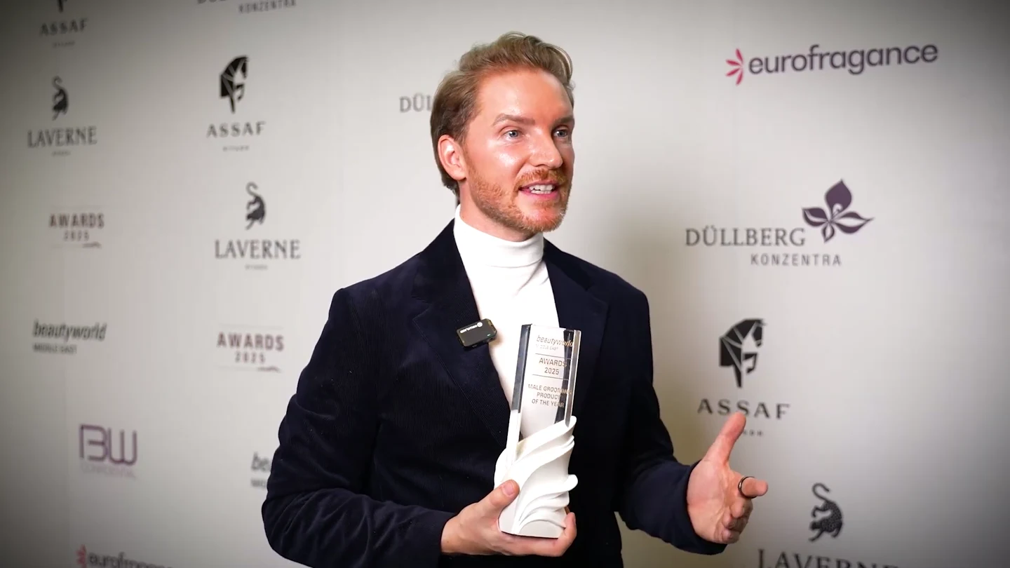 Kenneth Hoellmann holding the Beautyworld Middle East award during his winner interview